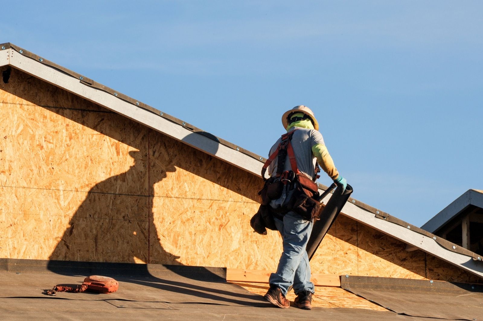 Roofing contractor installing roofing paper on a roof in stockton, ca